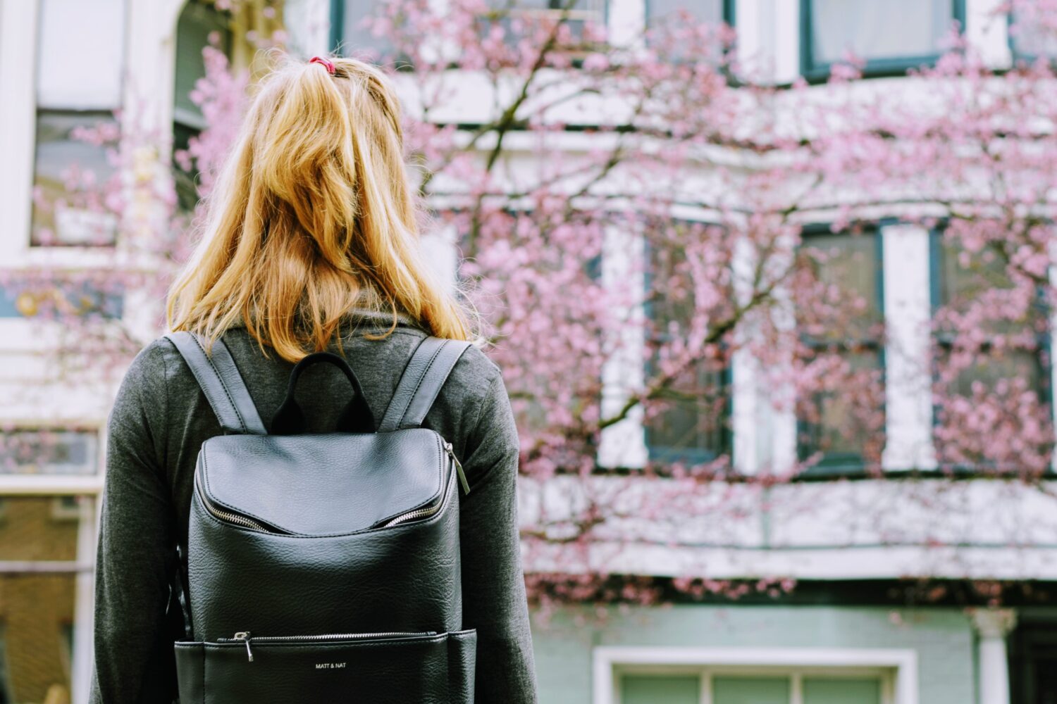 Student wearing a black backpack facing away from the camera.