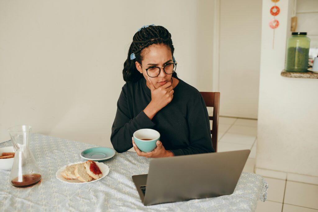 Woman in a black shirt in front of a laptop.